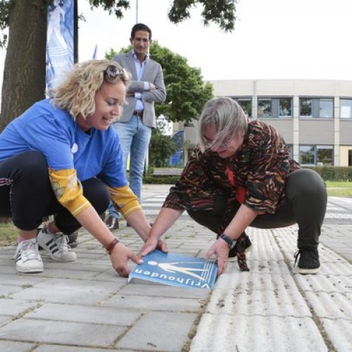 De wethouder plaatst in Huizen de eerste Houd de lijn vrij tegel