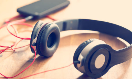 Smartphone met koptelefoon, op tafel