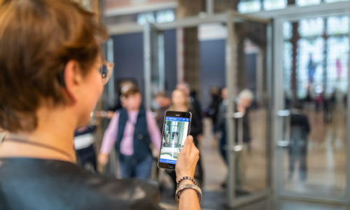 Vrouw met visuele beperking gebruikt de navigatie app op haar telefoon.