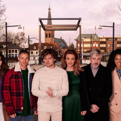 De cast van The Passion met in het midden verteller Ruud de Wild. Op de achtergrond een brug, huizen en een kerk in Doetinchem.