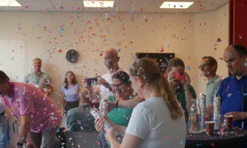 Vrijwilligers van de beleving schieten confettikanonnen af en de confetti dwarrelt door de lucht.