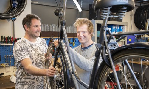 Dennis en Roel bij een te repareren fiets.