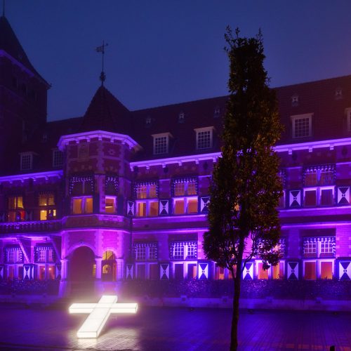 Het verlicht kruis staat voor het Gemeentehuis van Zeist dat paars verlicht is.
