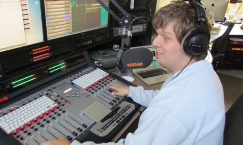 Radiopresentator met visuele beperking in studio Radio509.