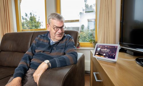 Bewoner Bert met naast zich de Google Home.