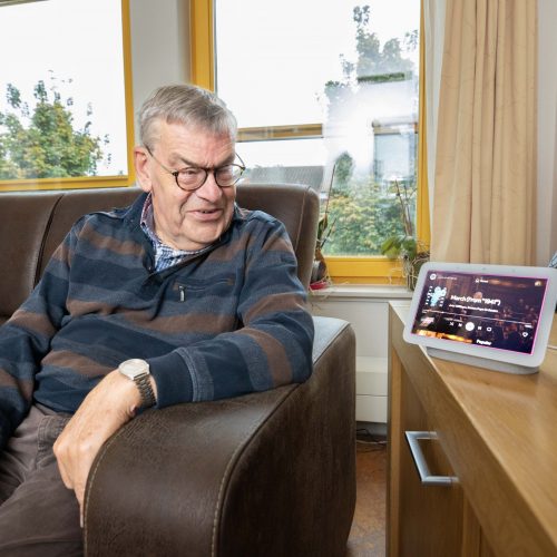 Bewoner Bert met naast zich de Google Home.