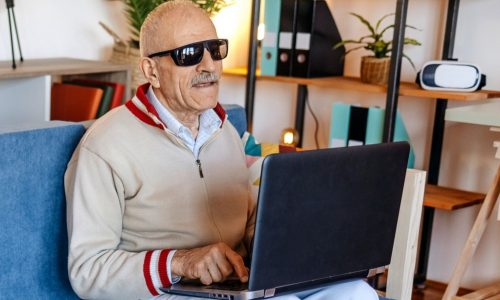 Blinde man zoekt op laptop naar info.