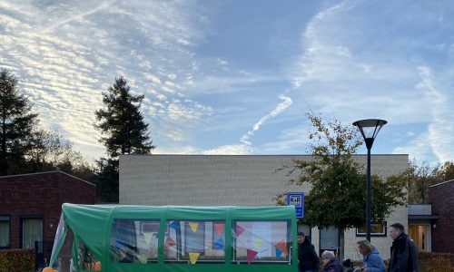 Bewoners worden in hun rolstoel in de mo-car gereden.