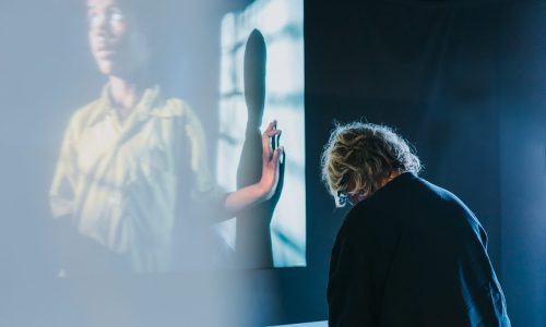 Een bezoeker voelt in muZIEum aan een 3D-print bij de tentoonstelling Unseen.