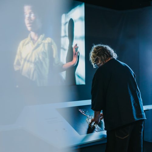 Een bezoeker voelt in muZIEum aan een 3D-print bij de tentoonstelling Unseen.