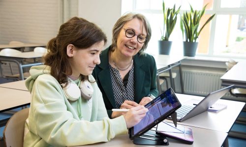 Lienke en Dijana zitten naast elkaar in de klas. Lienke maakt aantekeningen op de iPad.