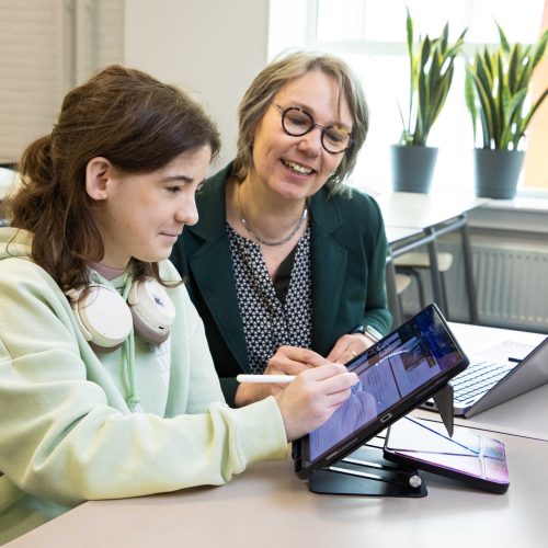 Lienke en Dijana zitten naast elkaar in de klas. Lienke maakt aantekeningen op de iPad.