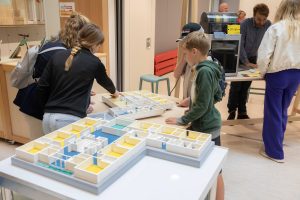 Kinderen bekijken en betasten de voelbare maquette van de inclusieve school.